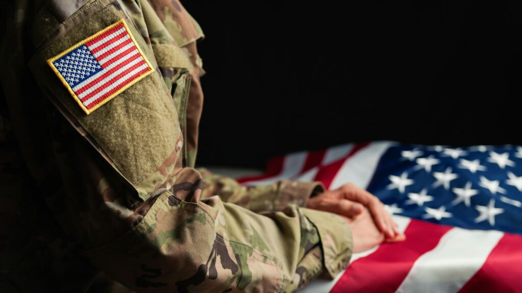 Hand of a Veteran touching stars of USA flag