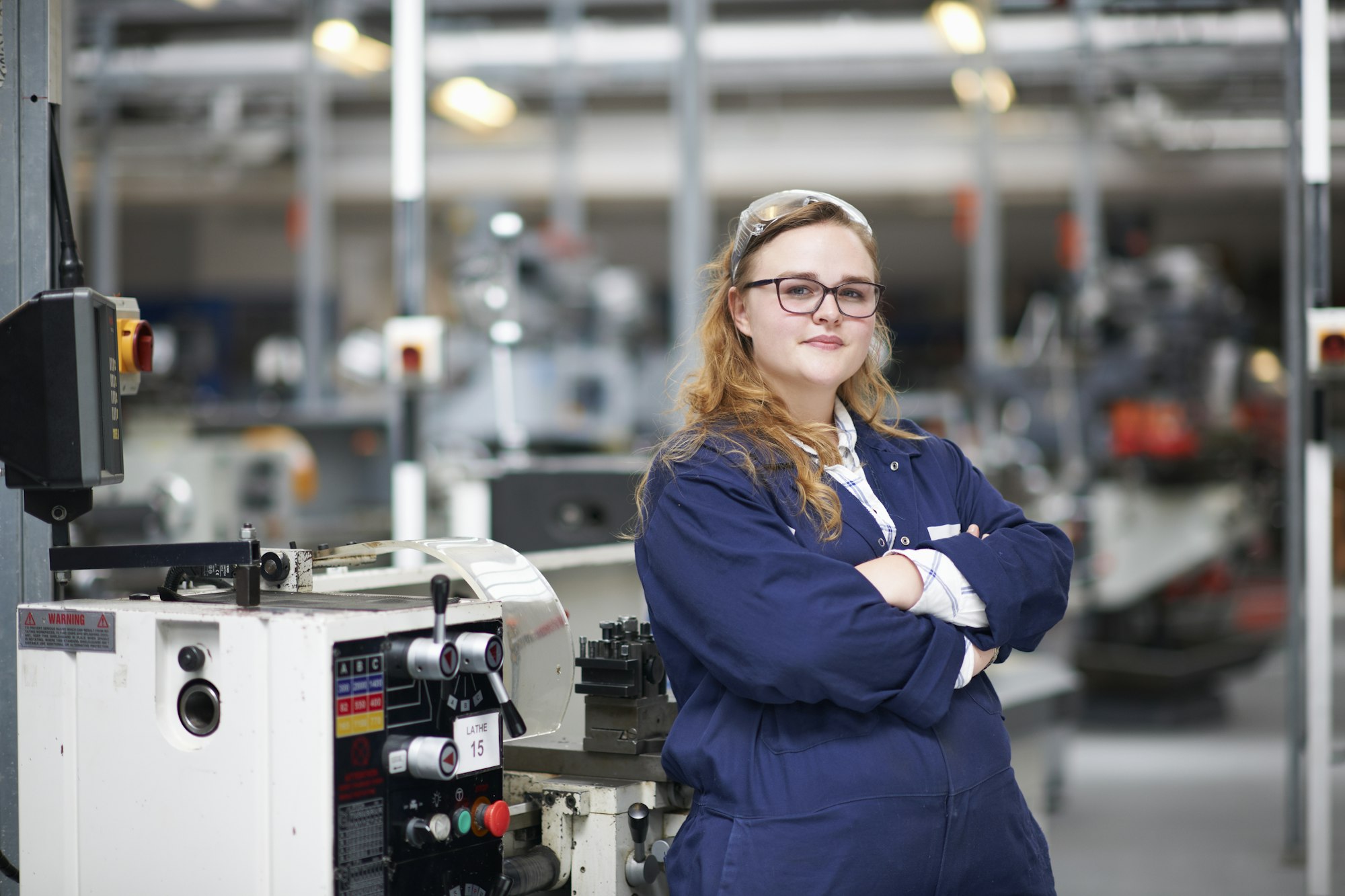 Portrait of female higher education student in machine workshop at college