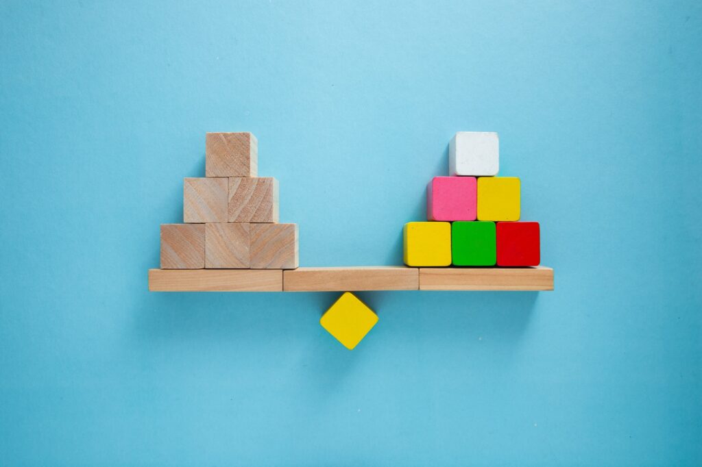 Balancing act: block outweighing stack of wooden cubes on seesaw