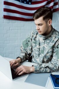 young military man using laptop in modern office