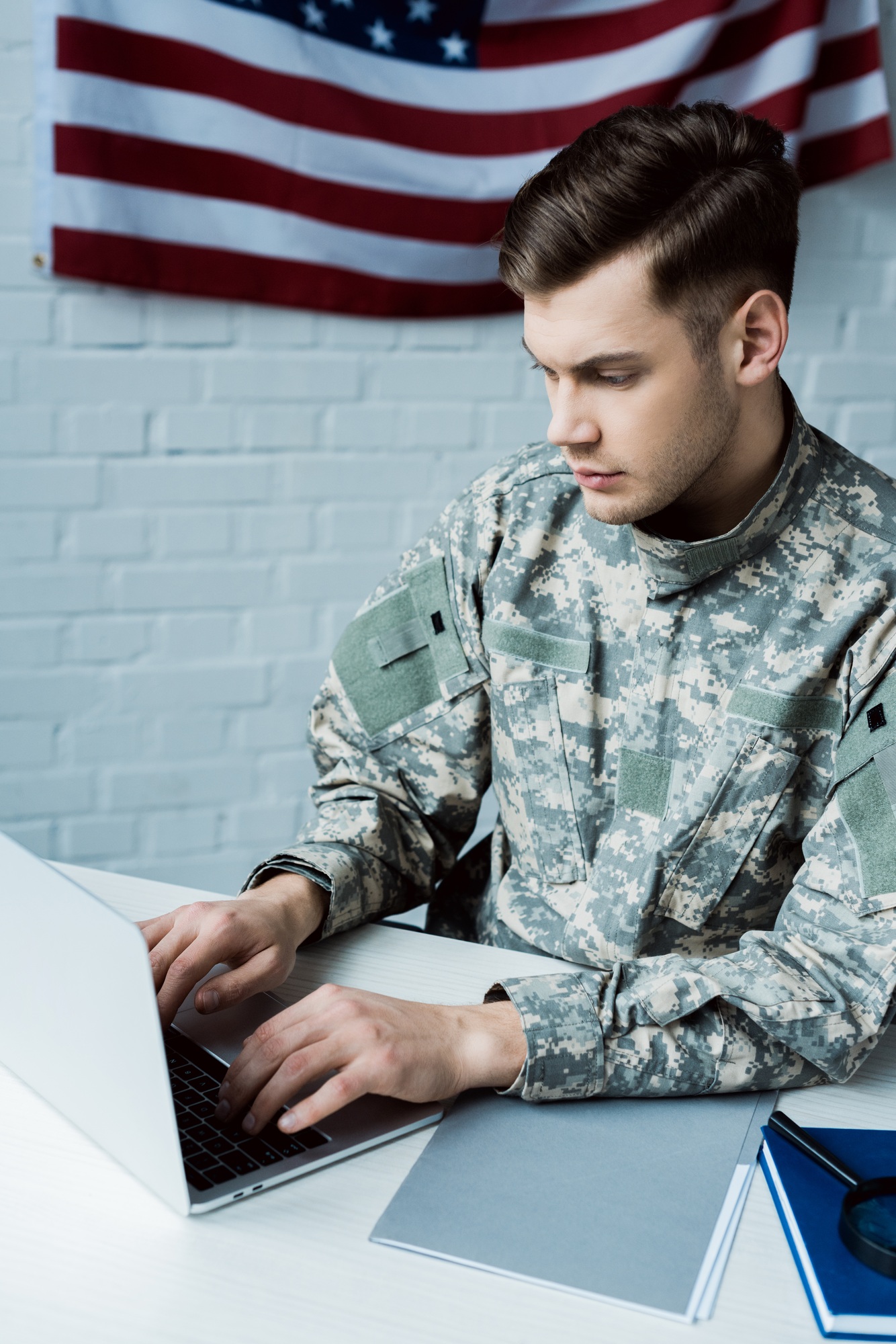 young military man using laptop in modern office