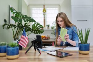 Young woman student studying at home online remotely, USA flag background
